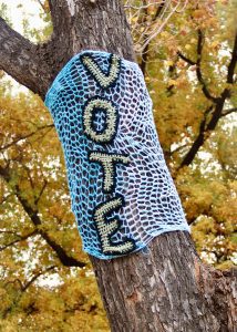 blue and white knit textile on brown tree trunk in Cumming GA