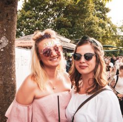 two woman standing near people at a summer festival in Forsyth County GA