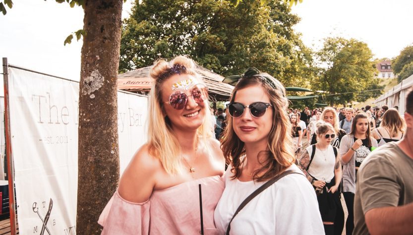 two woman standing near people at a summer festival in Forsyth County GA