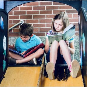 Kids reading books in Forsyth County park during summer
