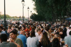 People enjoy outdoor dining at a crowded restaurant.
