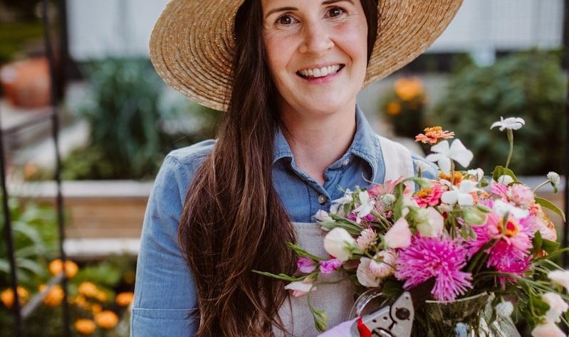 A woman holding a bouquet of flowers in a garden in FoCo