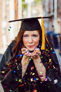 student blowing assorted color confettis