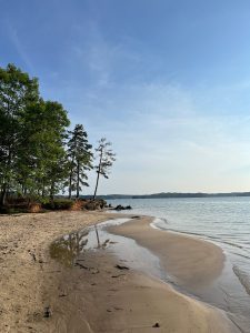 a sandy beach next to a body of water
